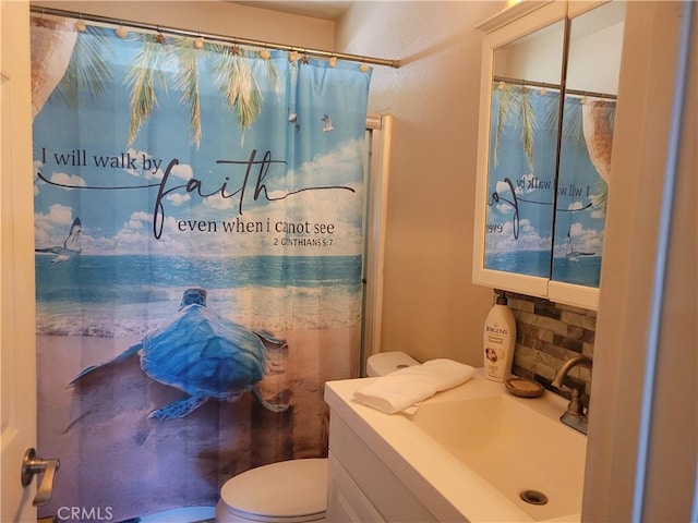 bathroom featuring vanity, backsplash, toilet, and curtained shower