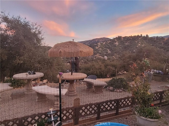 patio terrace at dusk featuring a mountain view