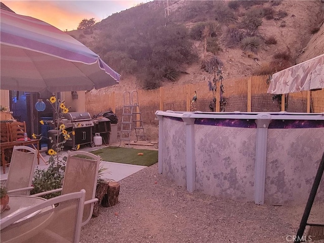 yard at dusk featuring a gazebo, a mountain view, and a patio