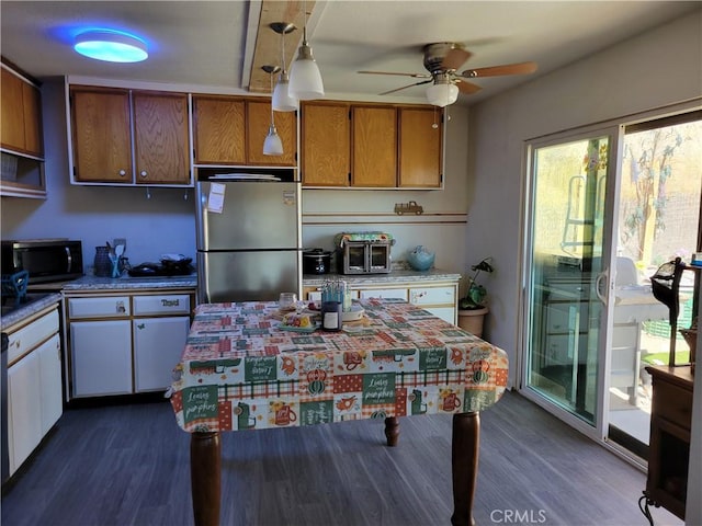 kitchen with stainless steel fridge, ceiling fan, dark wood-type flooring, decorative light fixtures, and white cabinets