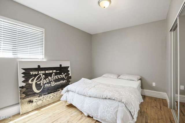 bedroom with a closet and hardwood / wood-style floors