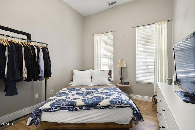 bedroom with multiple windows and light wood-type flooring