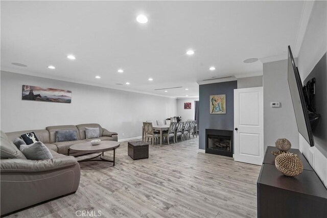 living room with light hardwood / wood-style floors and ornamental molding