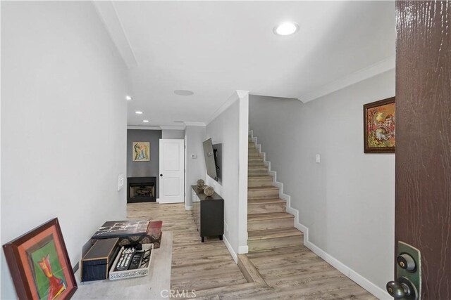 interior space with ornamental molding and light wood-type flooring