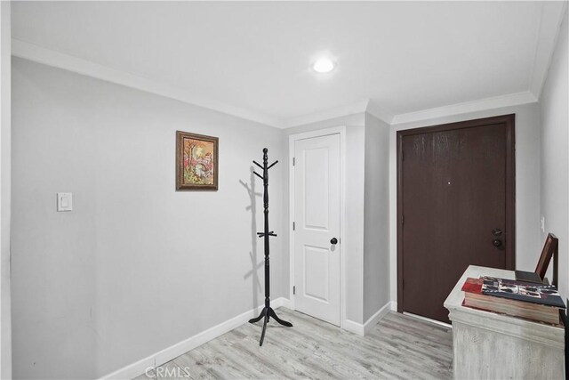 entrance foyer featuring ornamental molding and light hardwood / wood-style flooring