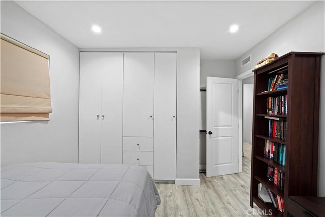 bedroom with a closet and light hardwood / wood-style floors