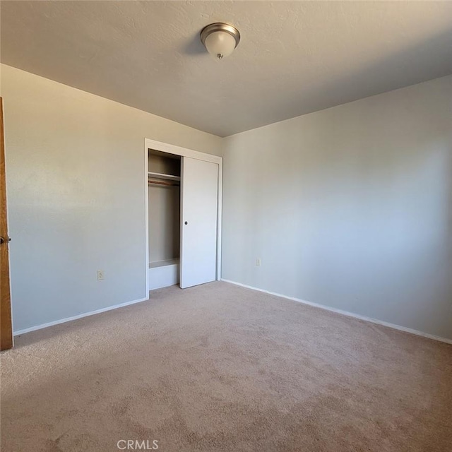 unfurnished bedroom featuring a closet and carpet floors