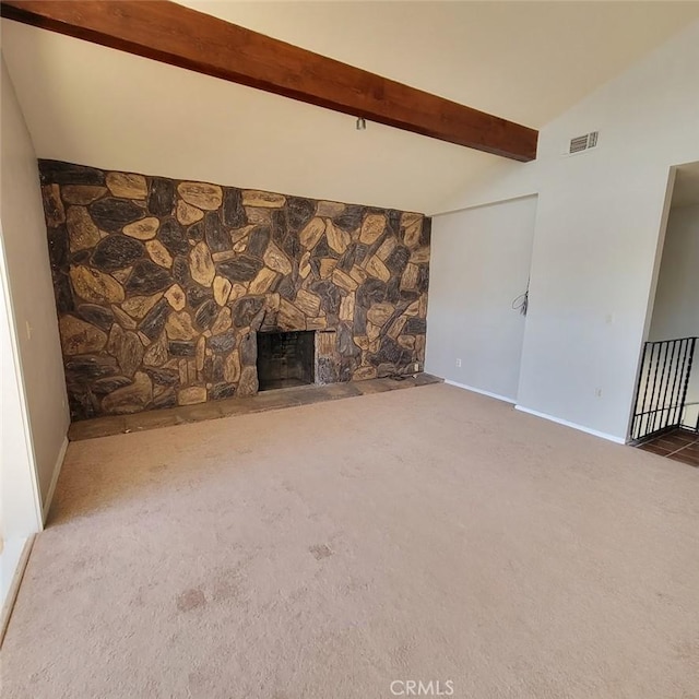 unfurnished living room with a fireplace, lofted ceiling with beams, and carpet flooring