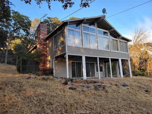 rear view of house featuring a sunroom