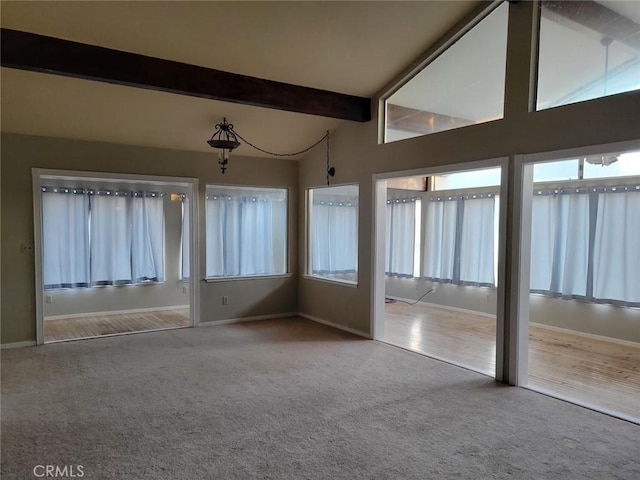 unfurnished sunroom with vaulted ceiling with beams