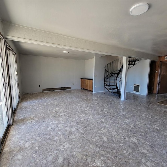 unfurnished living room featuring a baseboard heating unit