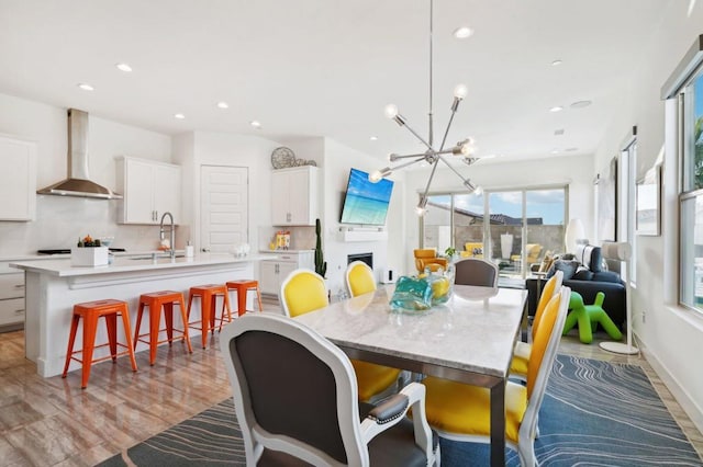 dining space featuring light hardwood / wood-style floors, sink, and an inviting chandelier