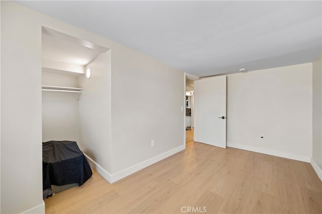 unfurnished bedroom with a closet and light hardwood / wood-style floors