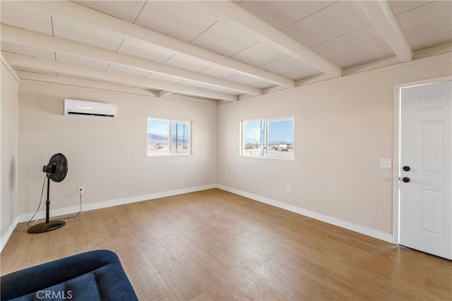 unfurnished room featuring beamed ceiling, a wall mounted AC, and hardwood / wood-style flooring