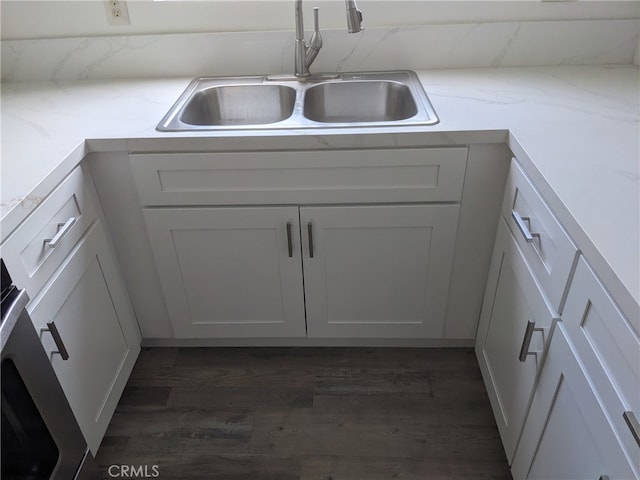 kitchen featuring dark wood-type flooring, sink, and white cabinetry