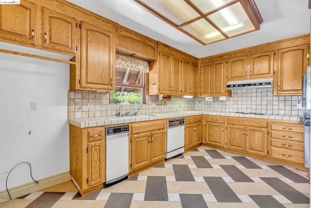 kitchen with decorative backsplash, dishwasher, tile countertops, sink, and stovetop