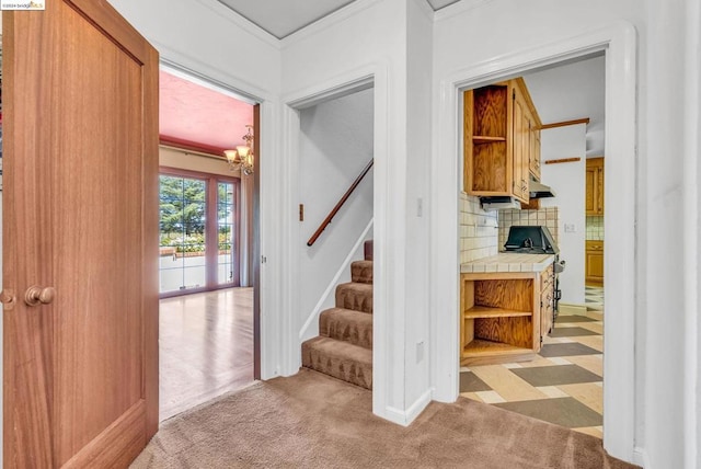 interior space with ornamental molding, a chandelier, and carpet flooring