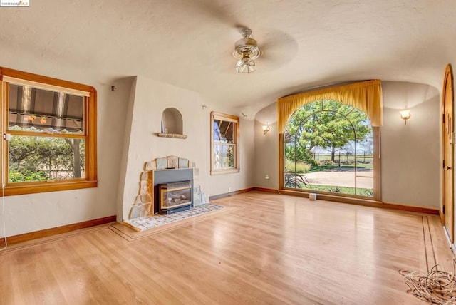 unfurnished living room with ceiling fan, hardwood / wood-style flooring, and vaulted ceiling