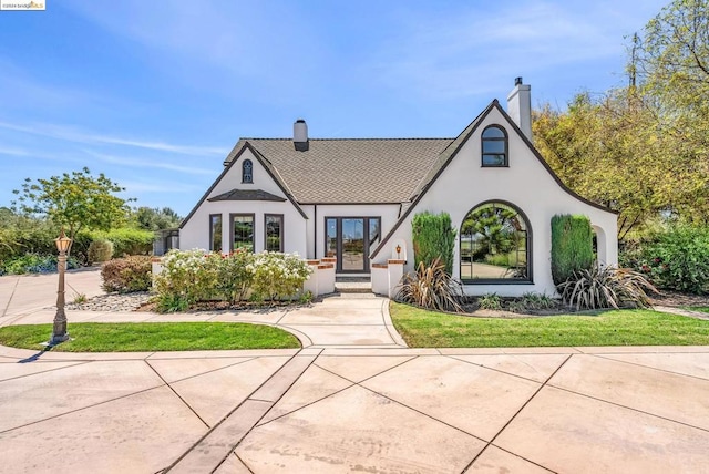 tudor-style house with a front yard