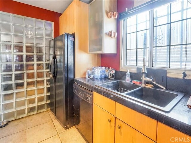 kitchen featuring light tile patterned floors, sink, and black appliances