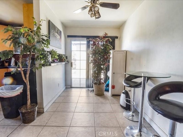 interior space with light tile patterned floors and ceiling fan