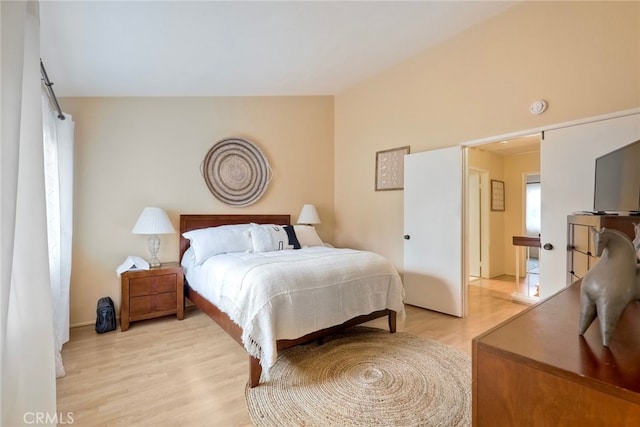 bedroom with light hardwood / wood-style flooring and vaulted ceiling