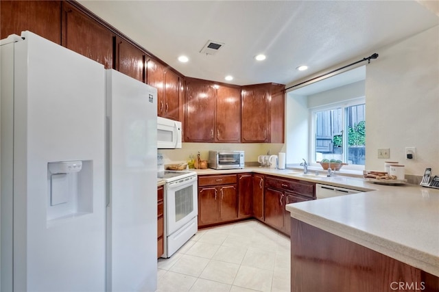 kitchen with light tile patterned flooring, kitchen peninsula, sink, and white appliances