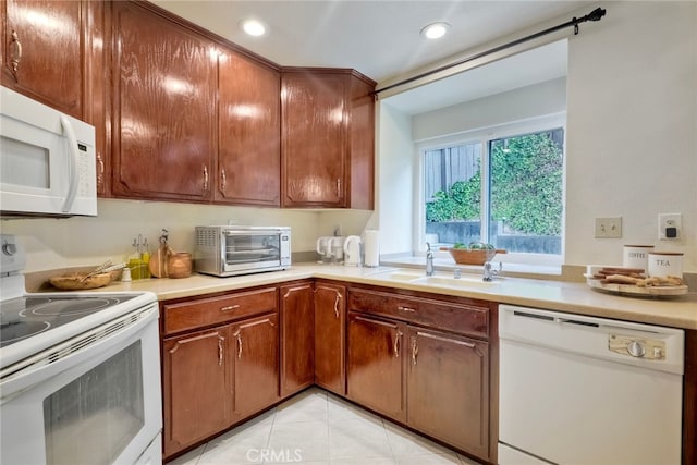 kitchen featuring light tile patterned flooring, sink, and white appliances