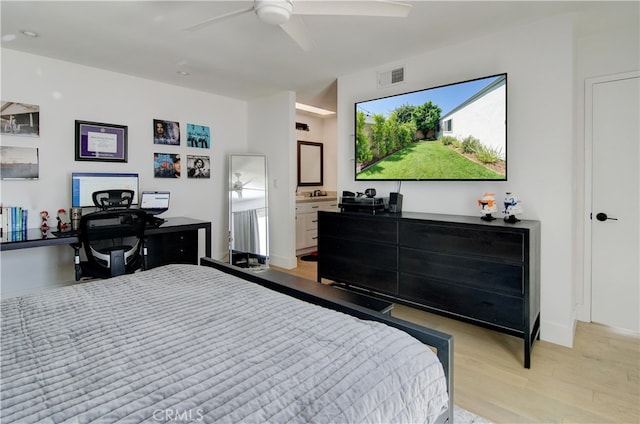 bedroom with ceiling fan, light hardwood / wood-style flooring, and connected bathroom