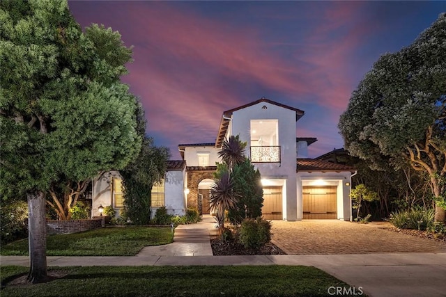 mediterranean / spanish home featuring a garage and a yard