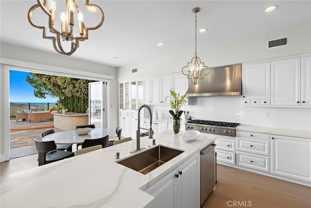 kitchen with white cabinetry, sink, dark hardwood / wood-style flooring, exhaust hood, and appliances with stainless steel finishes