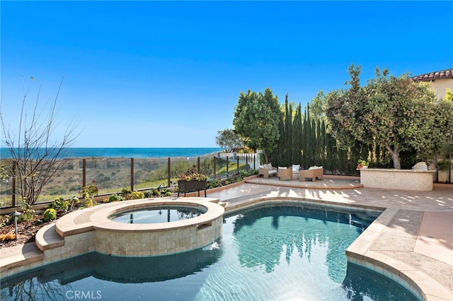 view of swimming pool featuring an in ground hot tub and a water view