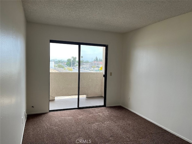 empty room featuring a textured ceiling and carpet flooring