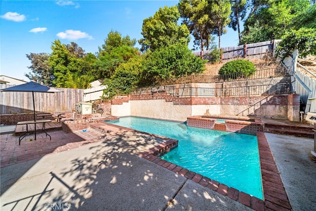 view of swimming pool featuring pool water feature and a patio area