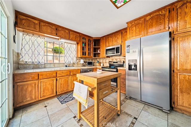 kitchen featuring stainless steel appliances, sink, and tasteful backsplash