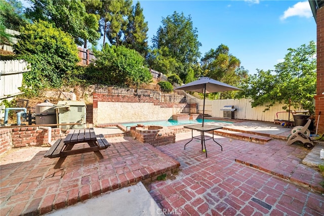 view of patio / terrace with area for grilling, a fenced in pool, and exterior kitchen