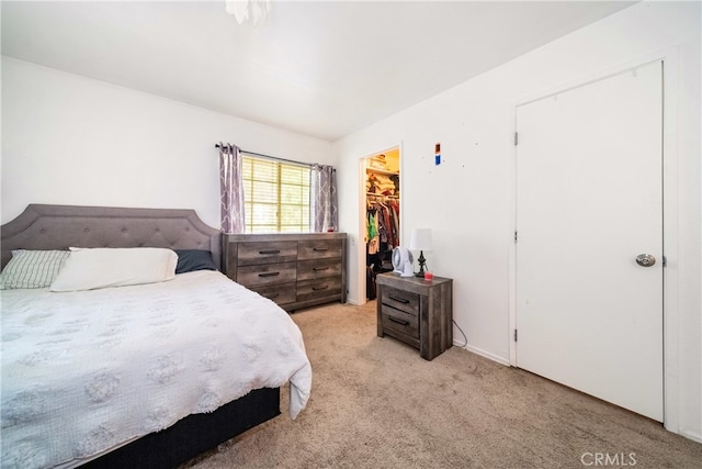 carpeted bedroom featuring a spacious closet and a closet