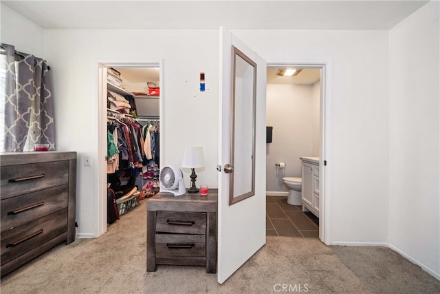 walk in closet with light carpet