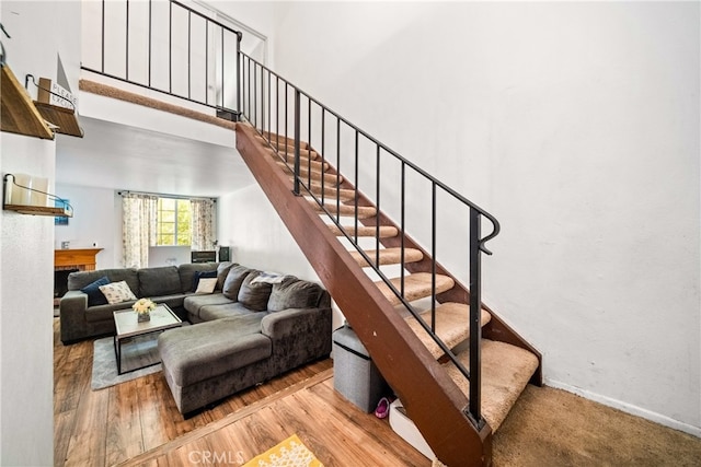 staircase with a towering ceiling and hardwood / wood-style floors