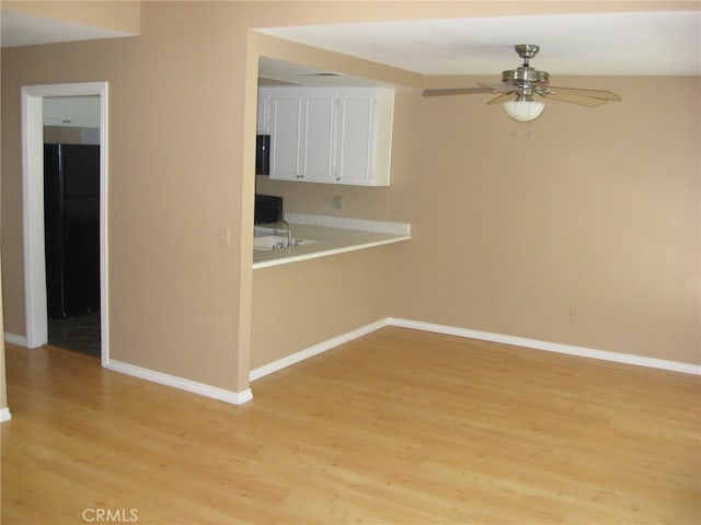 interior space featuring light hardwood / wood-style floors, white cabinetry, and ceiling fan