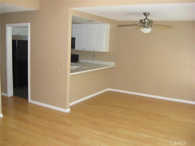 3431 Timber Lk Unit 46, Costa Mesa, CA 92626 - kitchen featuring light wood-style flooring, a ceiling fan, baseboards, and white cabinetry
