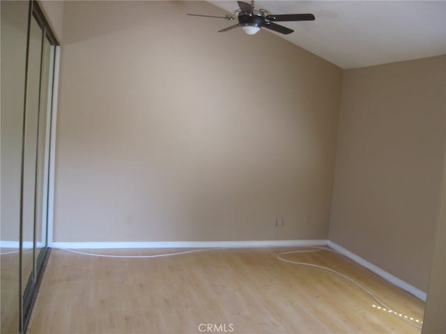 spare room with ceiling fan, vaulted ceiling, and light hardwood / wood-style floors