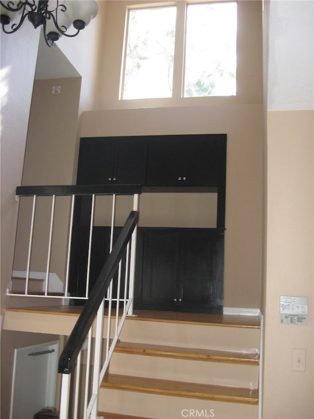 stairway with a notable chandelier and a wealth of natural light