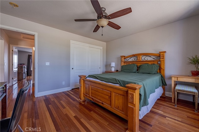 bedroom with dark wood-type flooring, a closet, and ceiling fan