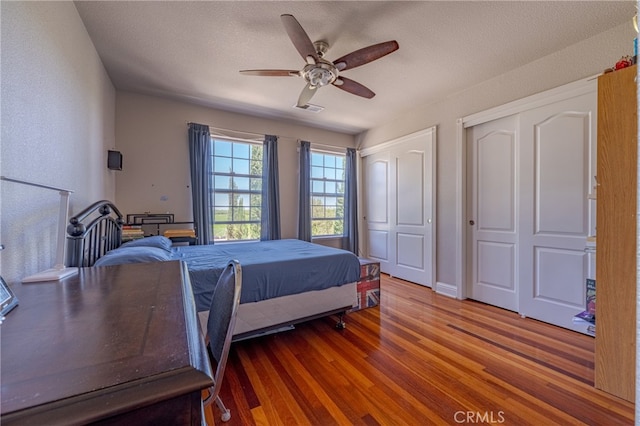 bedroom featuring ceiling fan, hardwood / wood-style floors, and a textured ceiling