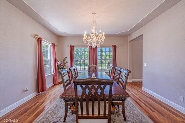 dining space featuring an inviting chandelier and light hardwood / wood-style floors