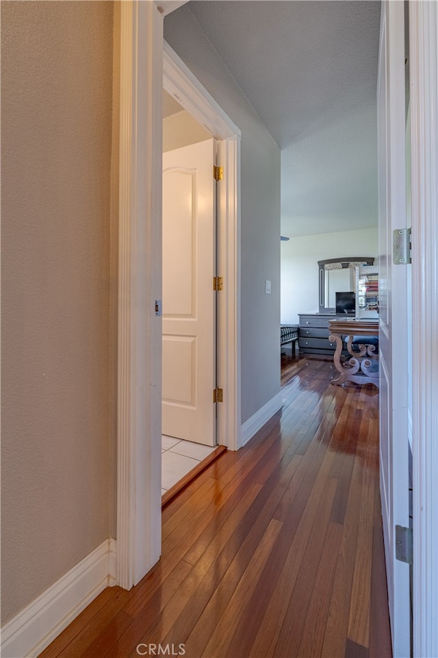 corridor with hardwood / wood-style floors