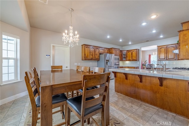 dining space with a chandelier and sink