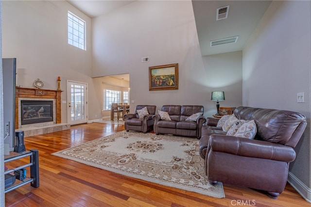 living room featuring hardwood / wood-style flooring and a towering ceiling