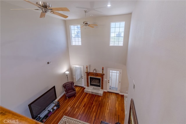 unfurnished living room featuring a healthy amount of sunlight, ceiling fan, and hardwood / wood-style floors